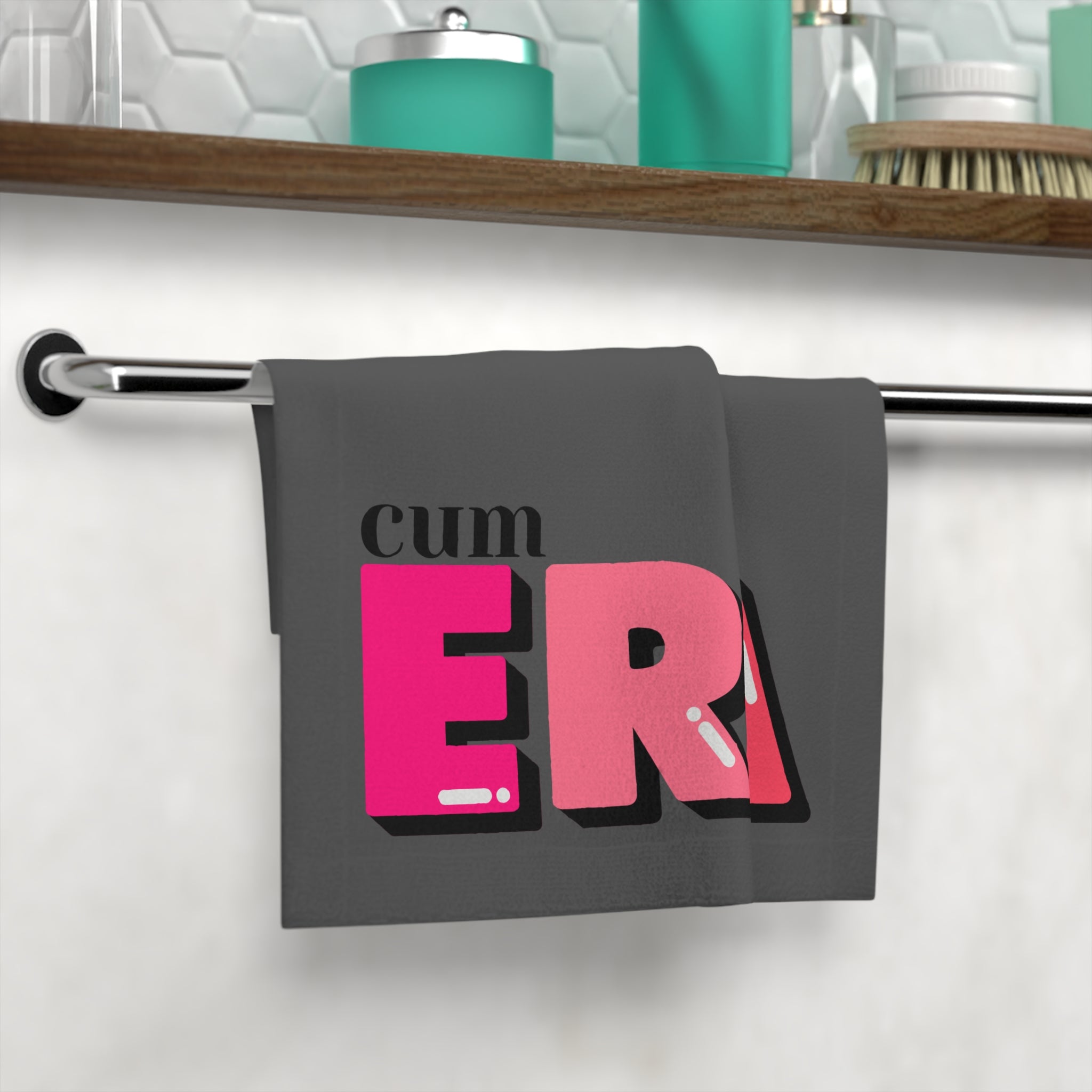 Cum Era After-Sex Cum Towel in dark gray with bold lettering, displayed on a bathroom towel rack. Perfect for playful and intimate use.